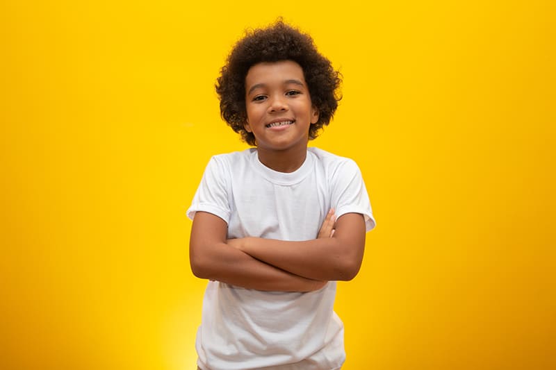 African American boy with black power hair on yellow background. Smiling Afro kid with a black power hair. Boy with a black power hair. African descent.